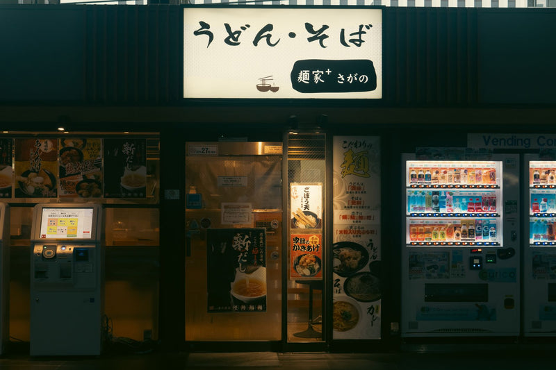 Night view of a Japanese restaurant and vending machines in Kyoto, Japan.