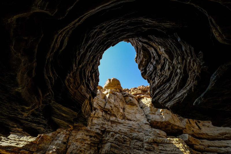 Explore the breathtaking view of the sky from within a limestone cave, highlighting natural rock formations.