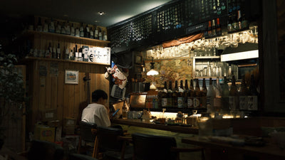 Cozy Japanese bar interior with dim lighting and wooden decor.