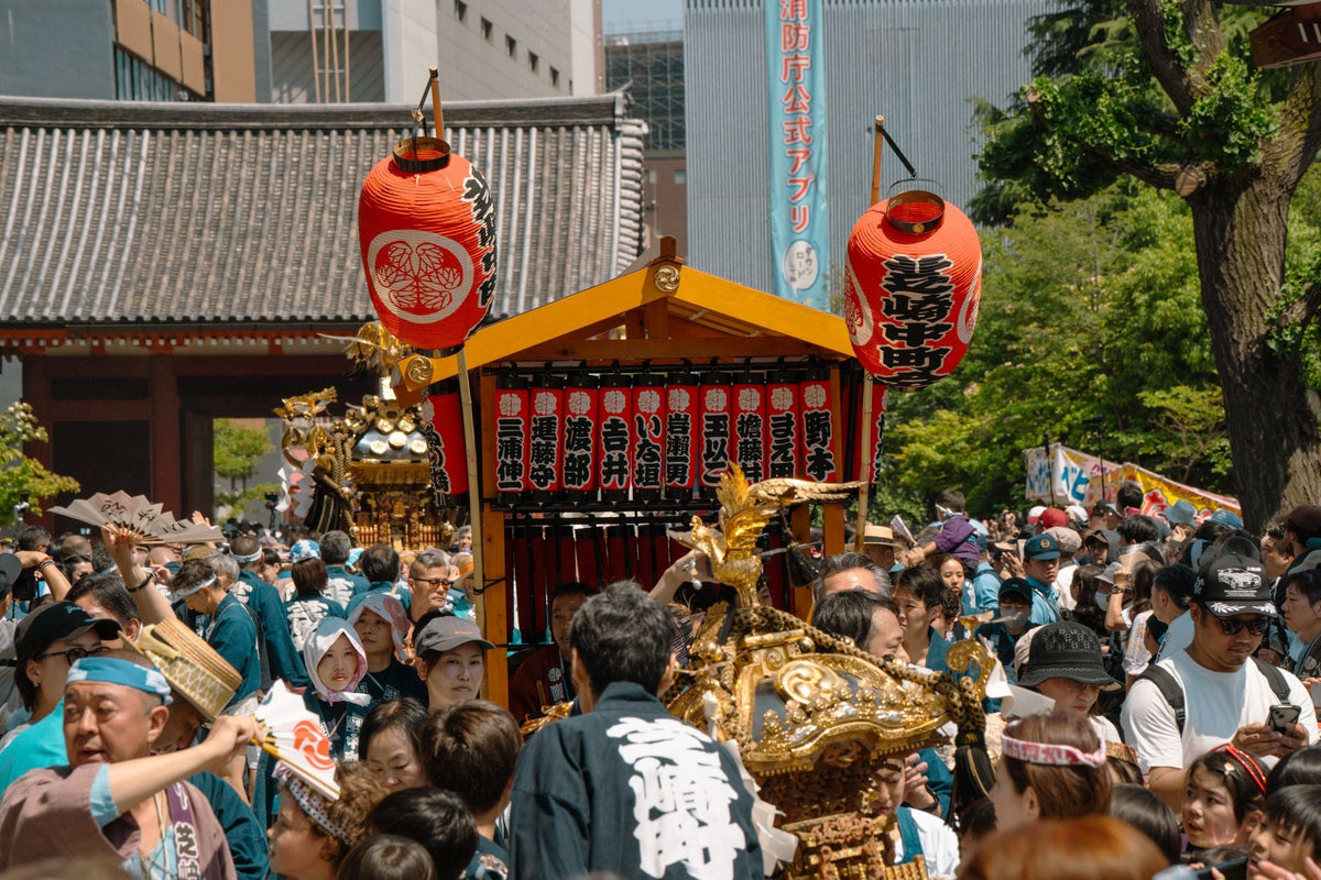 Vibrant festival scene in Tokyo with traditional mikoshi and crowd celebration.